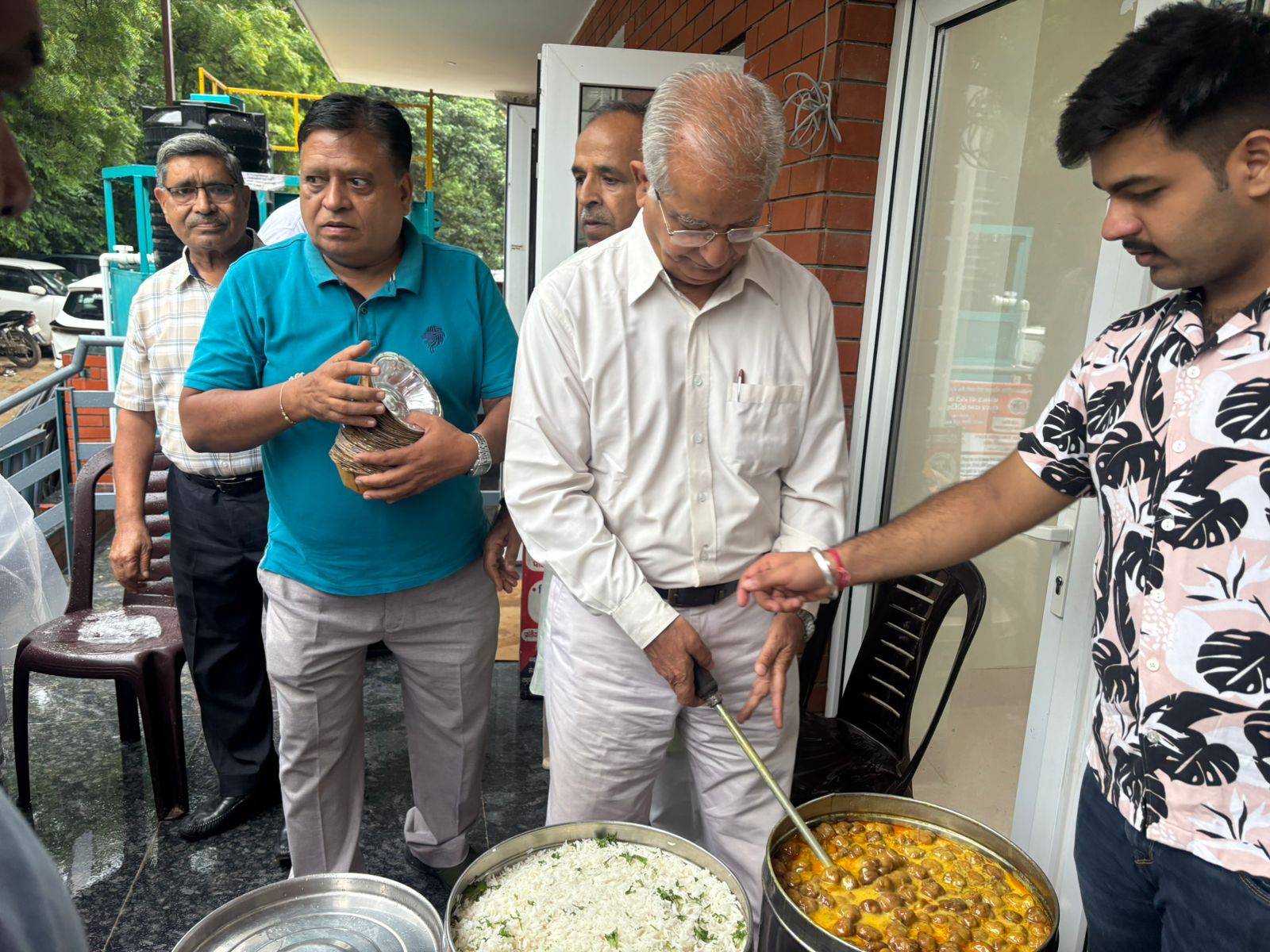 Trustees serving rice and chole during a community meal drive